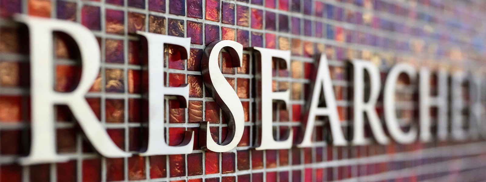 The word “research” adorns a red tile mosaic wall.