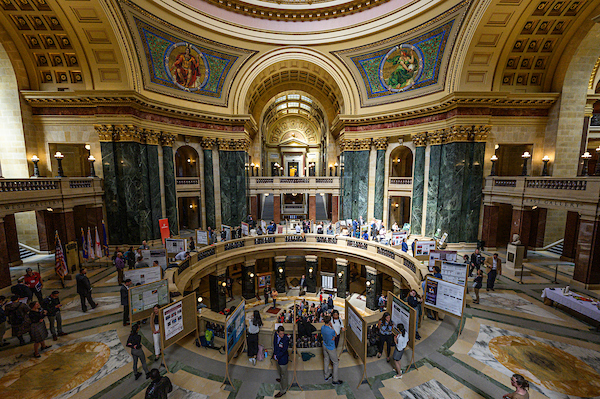 Wide-angle view of a Graduate Research Showcase poster session during UW–Madison's Day at the Capitol, taking place inside the Wisconsin Capitol building.