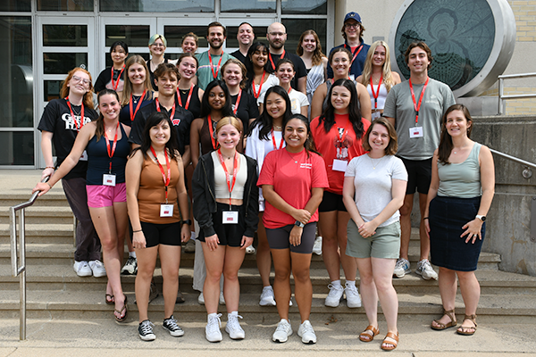 A group of WISCIENCE peer leaders and other students pose together outside.