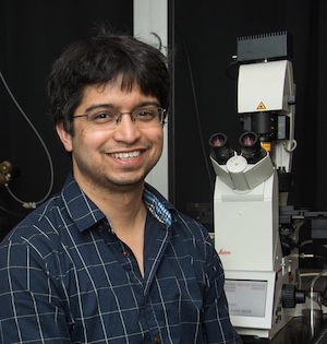 Headshot of Kinjal Majumder in front of lab equipment.
