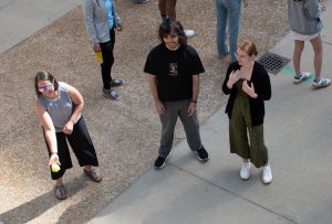 Amber Smith, Associate Director of WISCIENCE, smiles while catching a tennis ball in a community building activity. Two CMBS students stand next to her, smiling.