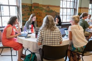 The CCTT project team, including several WISCIENCE staff members, sits around a table with laptops. 