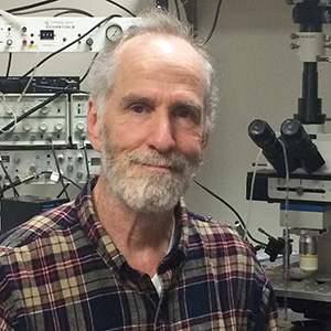 Headshot of Meyer Jackson in front of lab equipment.