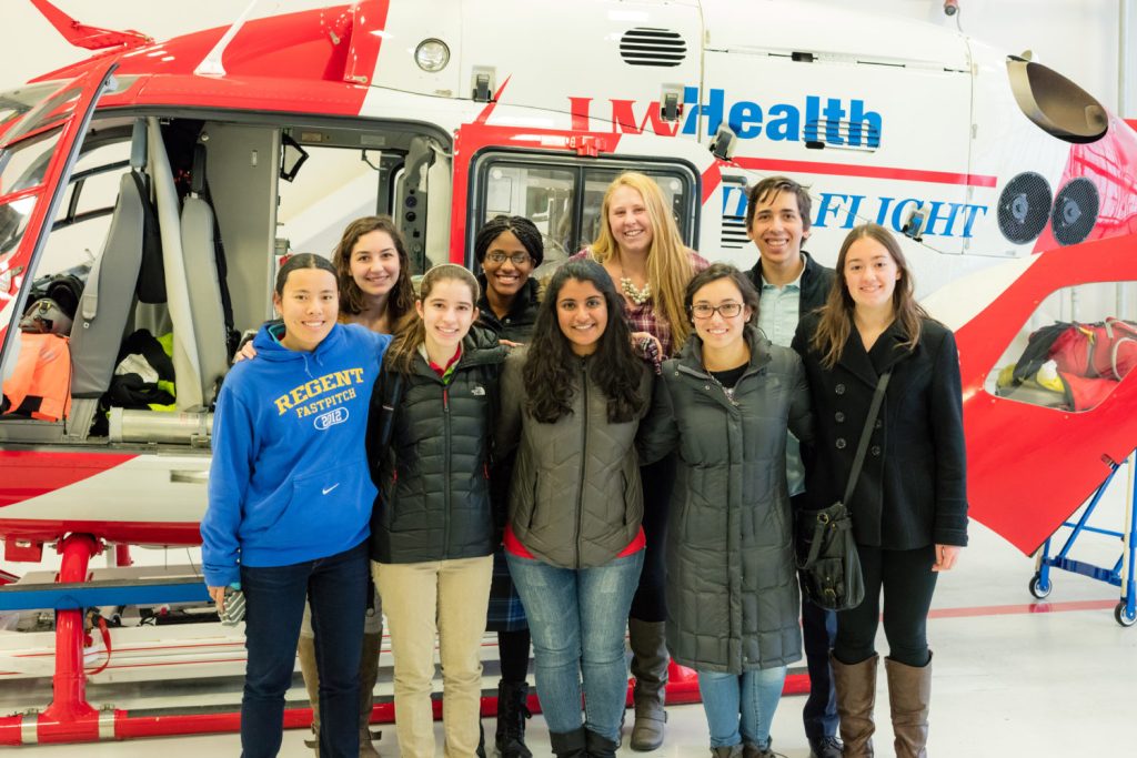 Several BioHouse residents stand in front of the UW–Health med flight helicopter.