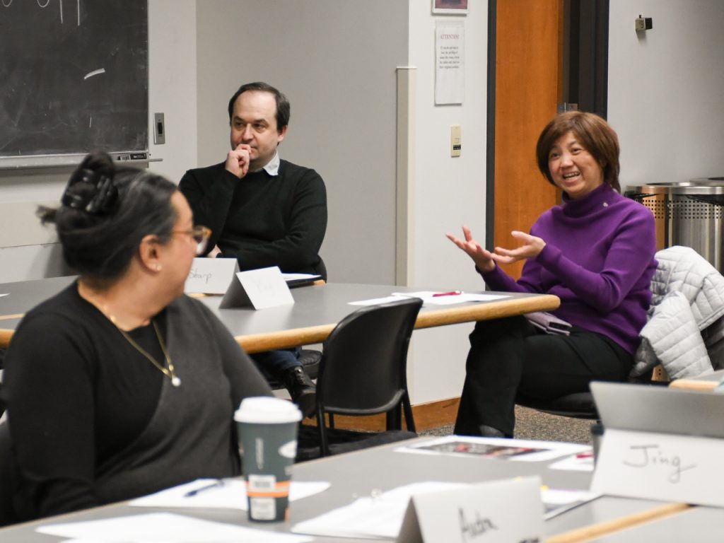 An ARMP participant gestures as she speaks, while 2 other participants listen to her.