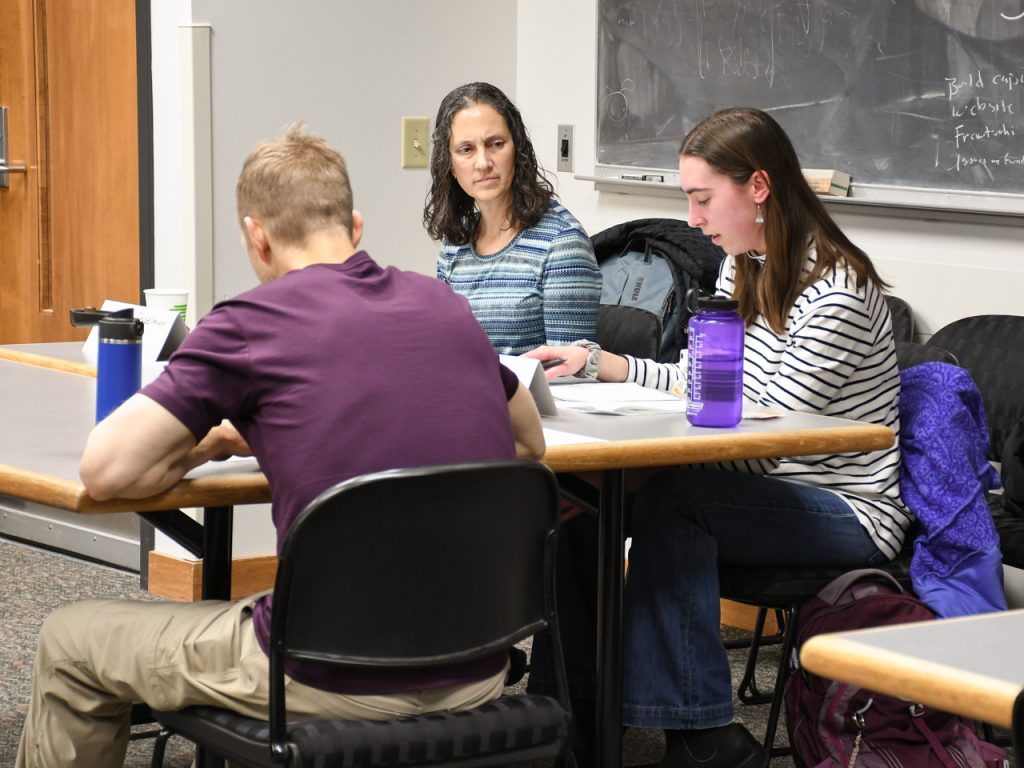 Three ARMP participants sit at a table together in a classroom.