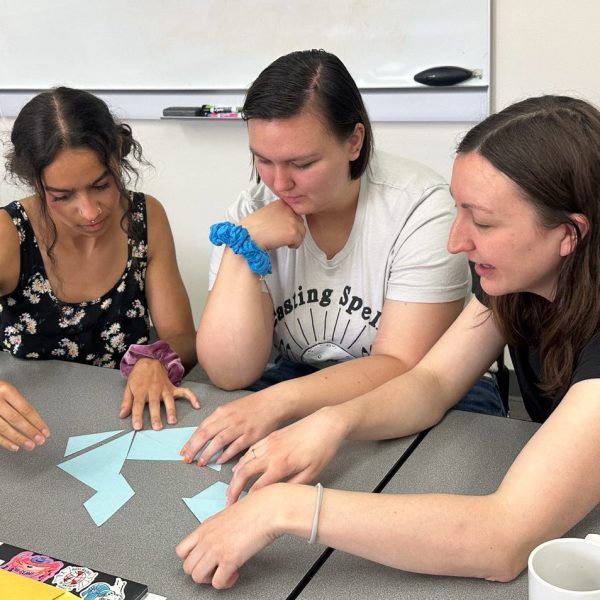 Three STEM Public Service Fellows work together on a project.