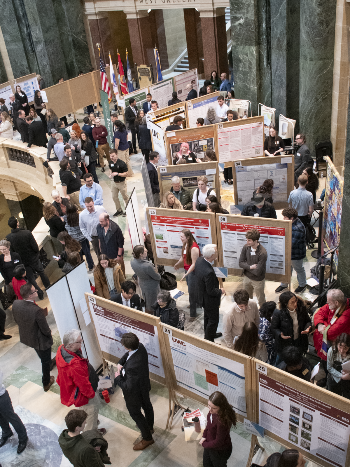 An overhead view of Research in the Rotunda—looking down at numerous students presenting posters while many attendees walk around and view them.